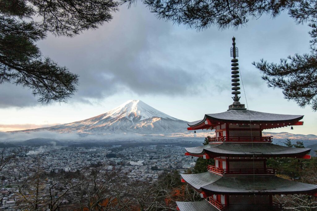 Helicopter soaring over Tokyo skyline with Mount Fuji in the distance.