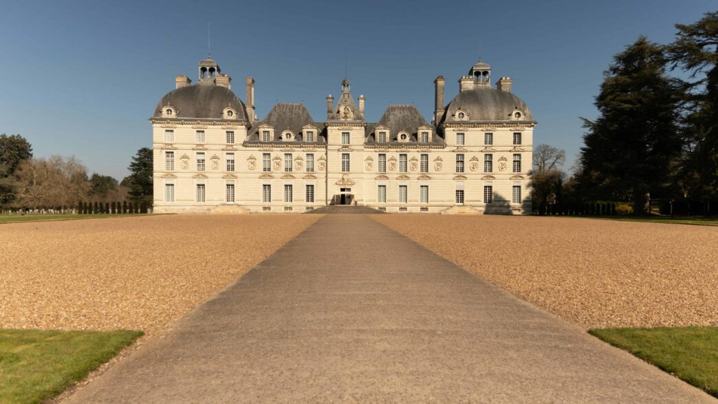 a large white building with a path leading to it with Château de Cheverny in the background
