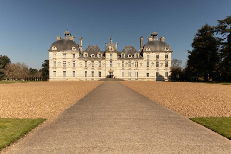 a large white building with a path leading to it with Château de Cheverny in the background