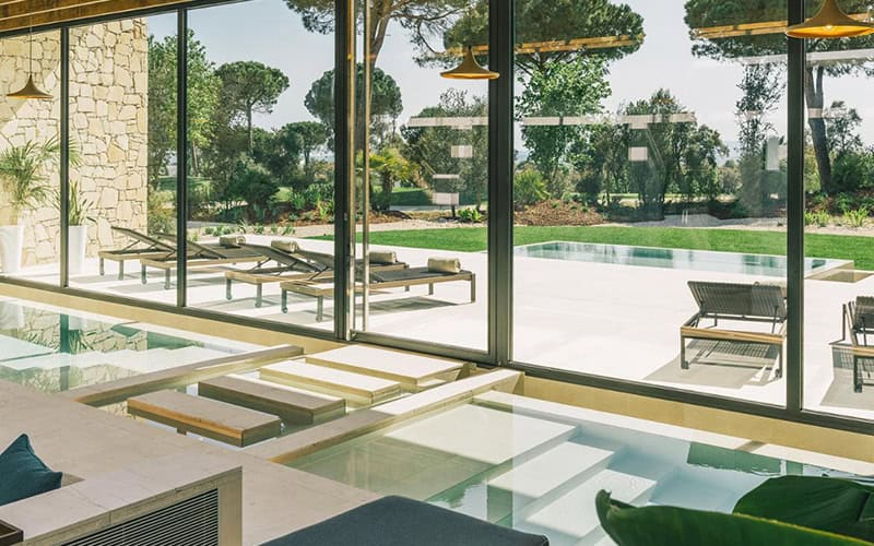 Luxury Wellness Retreats 2025: 7 Elite Biohacking Destinations 28 Luxury wellness retreats 2025 - Camiral Wellness Centre holistic spa with floor-to-ceiling windows, modern relaxation pools, natural stone walls, and Mediterranean garden views for integrated healing programs