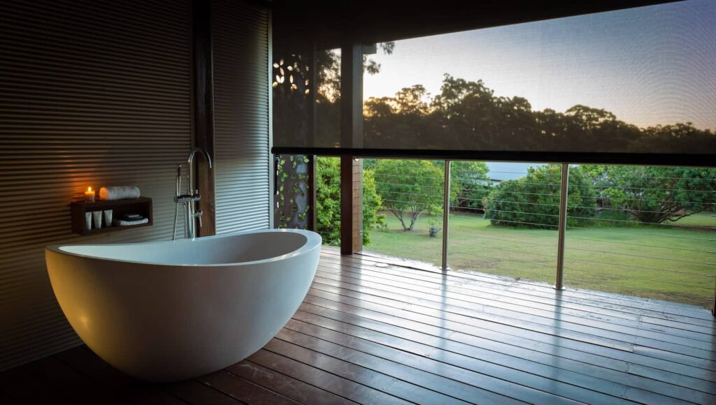 Luxury Wellness Retreats 2025: 7 Elite Biohacking Destinations 29 Luxury wellness retreats 2025 - Gwinganna Lifestyle Retreat modern bathroom with freestanding bathtub, floor-to-ceiling windows overlooking natural landscape, and warm lighting for digital detox excellence programs