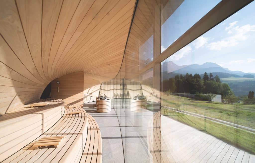 Luxury Wellness Retreats 2025: 7 Elite Biohacking Destinations 27 Luxury wellness retreats 2025 - Hotel Krallerhof innovative Alpine sauna with curved wooden architecture, panoramic mountain views, and modern glass design for high-altitude wellness training