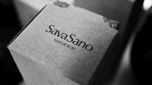 SavaSano "Natur Pur" product packaging in minimalist black and white photography, showing premium Swiss cosmetic branding