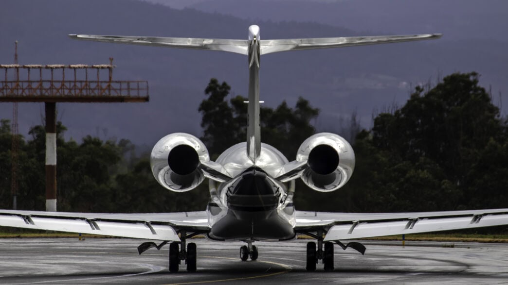 Private jet flying over Swiss Alps en route from Zurich to Dubai with sunrise lighting