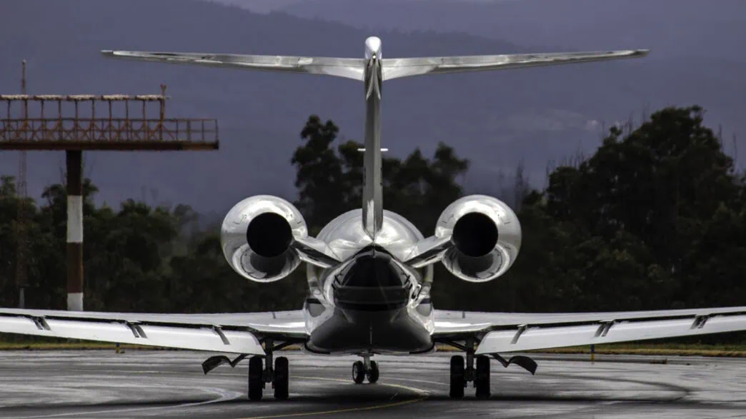Private jet flying over Swiss Alps en route from Zurich to Dubai with sunrise lighting