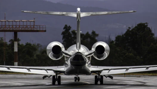Private jet flying over Swiss Alps en route from Zurich to Dubai with sunrise lighting