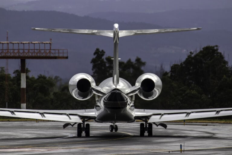 Private jet flying over Swiss Alps en route from Zurich to Dubai with sunrise lighting