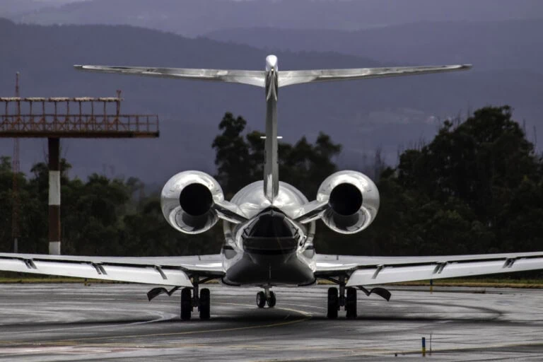 Private jet flying over Swiss Alps en route from Zurich to Dubai with sunrise lighting