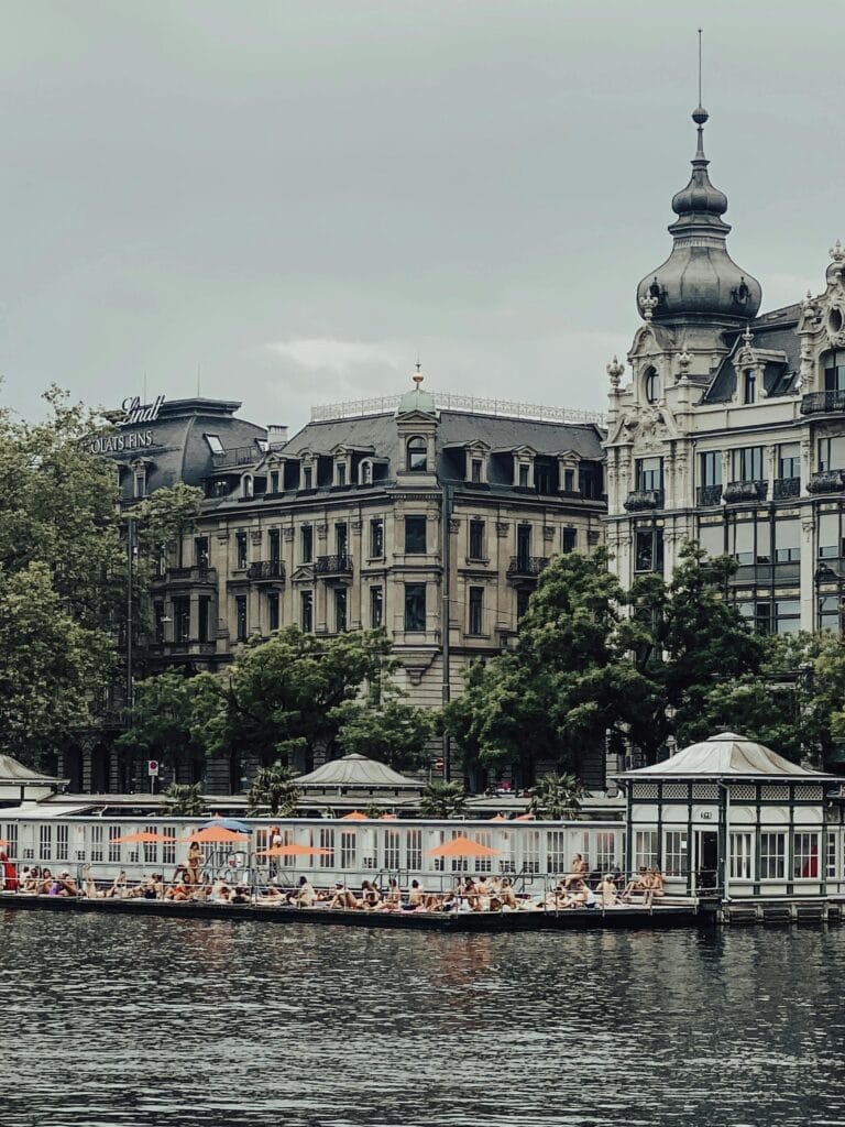 Zurich Lake Limmat River summer swimming badi public bathing area with Alps in background